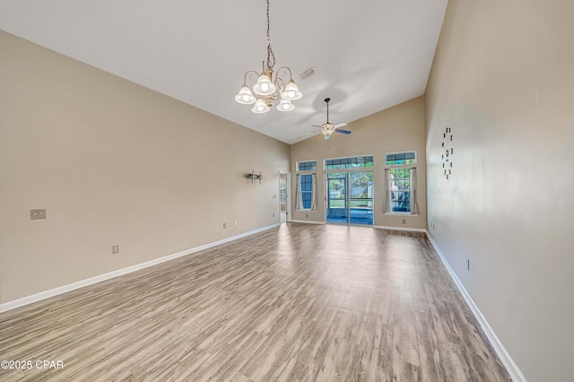 empty room featuring ceiling fan with notable chandelier, visible vents, light wood-style flooring, and baseboards