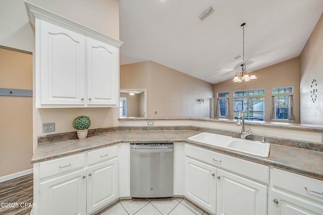 kitchen with dishwasher, dark countertops, a sink, and white cabinets