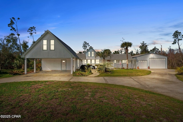 view of front facade featuring driveway, a garage, a front yard, and an outdoor structure