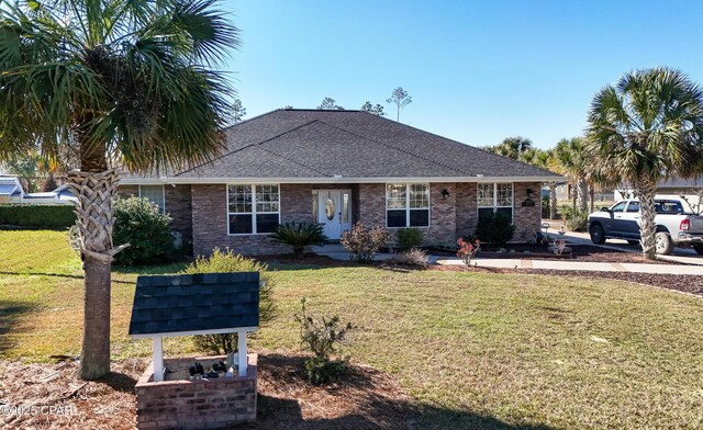 view of front of home featuring roof with shingles and a front yard