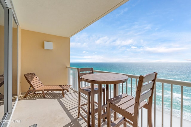 balcony featuring a water view and a beach view