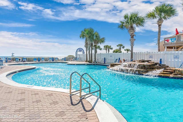 pool with a patio area and fence