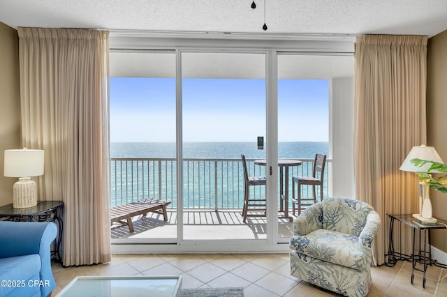 interior space featuring a water view, a textured ceiling, and tile patterned flooring