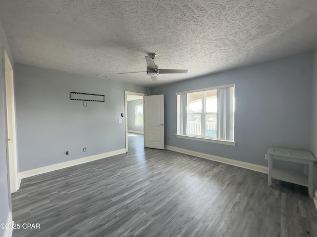 interior space featuring dark wood-style floors, ceiling fan, baseboards, and a textured ceiling