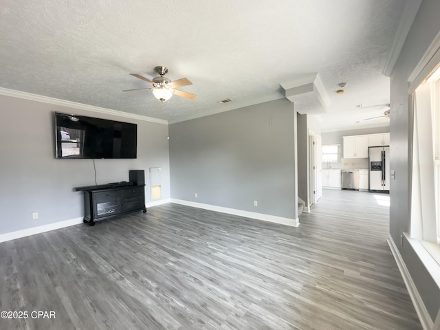 unfurnished living room with ornamental molding, a textured ceiling, and a ceiling fan