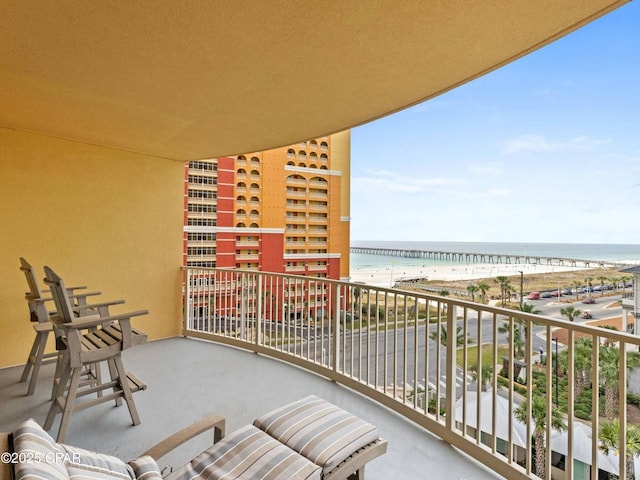 balcony featuring a water view and a beach view