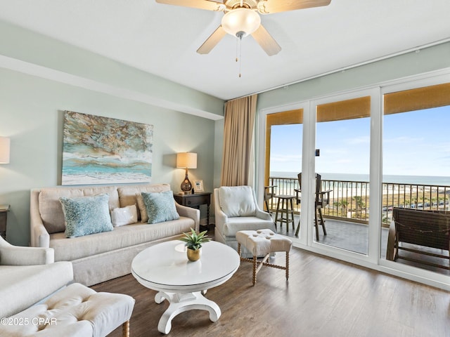 living room with a water view, hardwood / wood-style flooring, and ceiling fan