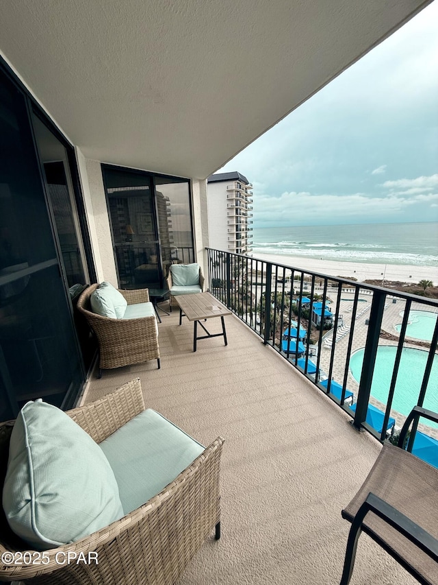 balcony with a water view and a beach view