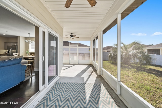 sunroom / solarium featuring a wealth of natural light and ceiling fan with notable chandelier