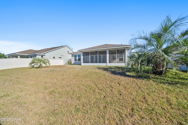 rear view of house featuring a sunroom, a fenced backyard, and a yard