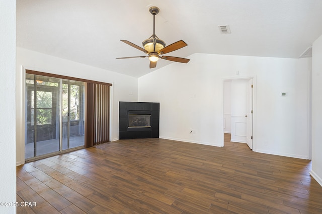 unfurnished living room with dark wood finished floors, lofted ceiling, visible vents, ceiling fan, and a tile fireplace