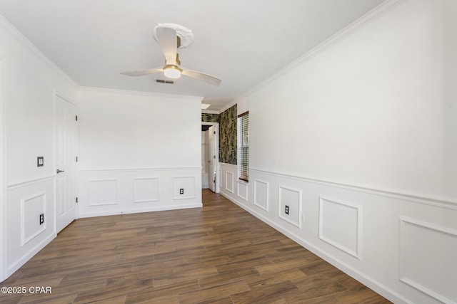 unfurnished room featuring a wainscoted wall, wood finished floors, visible vents, a ceiling fan, and ornamental molding