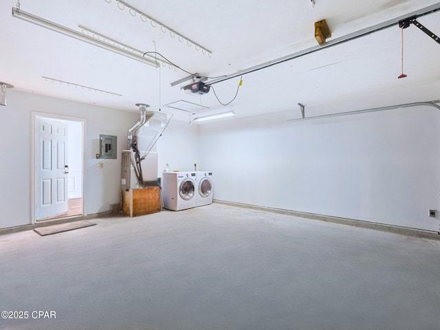 garage with washing machine and clothes dryer and electric panel