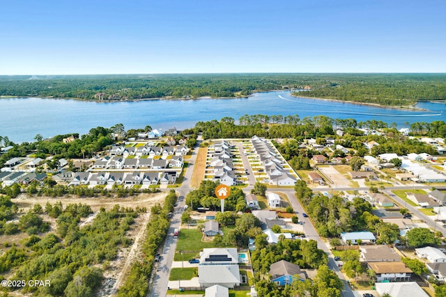 drone / aerial view featuring a water view, a residential view, and a view of trees