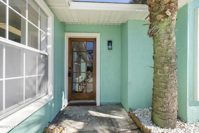 property entrance with stucco siding