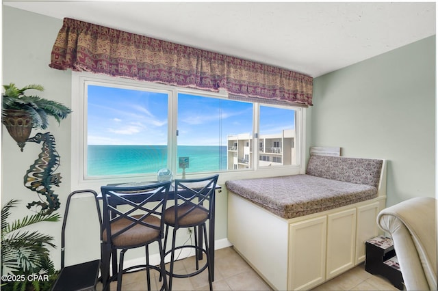 bedroom with a water view and light tile patterned flooring