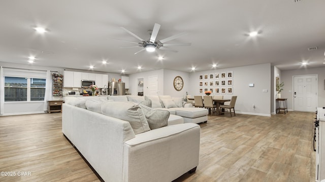 living room with recessed lighting, visible vents, light wood-style floors, a ceiling fan, and baseboards