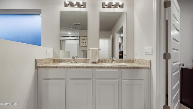 bathroom featuring double vanity, visible vents, and a sink