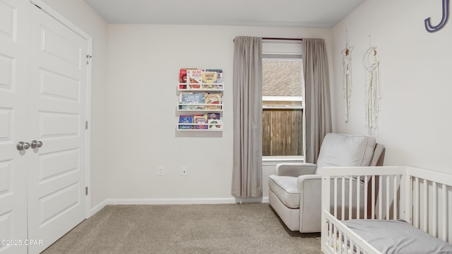 bedroom featuring a nursery area, baseboards, and light colored carpet