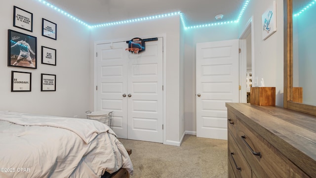 bedroom with light carpet, baseboards, and a closet