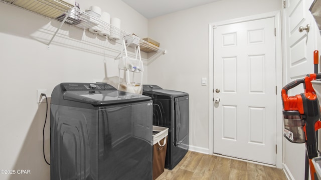 laundry area featuring light wood-style floors, laundry area, baseboards, and washing machine and clothes dryer