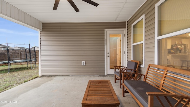 view of patio / terrace featuring a trampoline, fence, and a ceiling fan