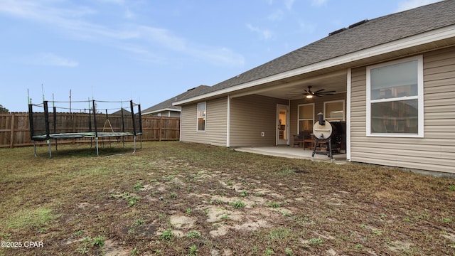 view of yard with ceiling fan, a trampoline, a patio area, and a fenced backyard