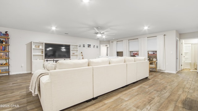 living room featuring light wood-style floors, recessed lighting, baseboards, and a ceiling fan