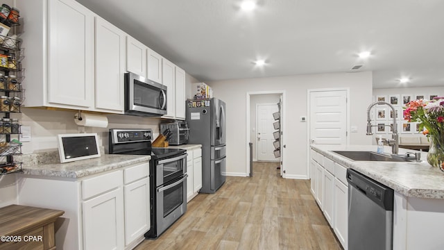 kitchen featuring light countertops, appliances with stainless steel finishes, and white cabinets