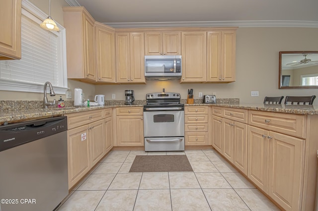 kitchen with ornamental molding, light brown cabinetry, appliances with stainless steel finishes, and light tile patterned floors