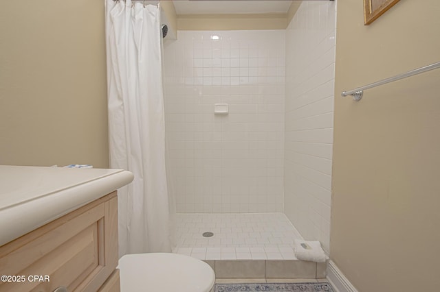 bathroom with toilet, a stall shower, and vanity