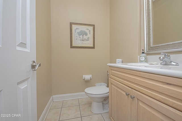 half bathroom with baseboards, vanity, toilet, and tile patterned floors