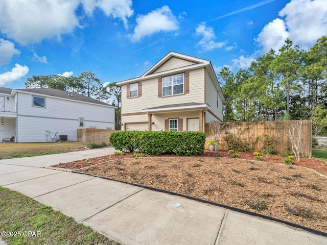 view of front of house featuring driveway, central air condition unit, an attached garage, and fence