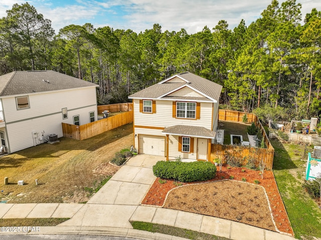 traditional-style house with a garage, central AC unit, concrete driveway, roof with shingles, and fence