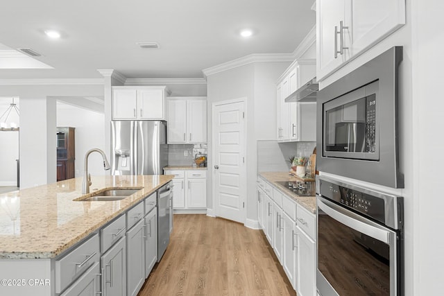 196 Martingale Loop, Lynn Haven, FL 32444 - kitchen with appliances with stainless steel finishes, a sink, ornamental molding, white cabinetry, and wall chimney exhaust hood