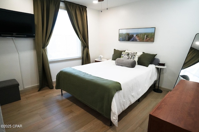 bedroom with baseboards and wood finished floors