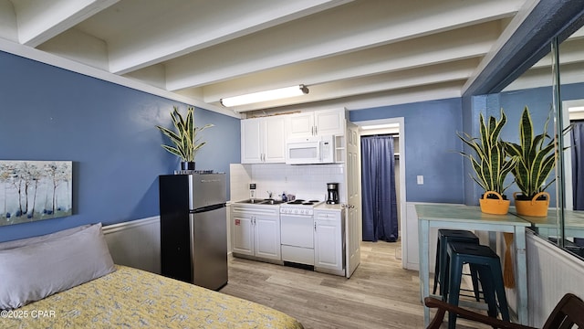 kitchen featuring white cabinets, white appliances, light wood finished floors, and beam ceiling