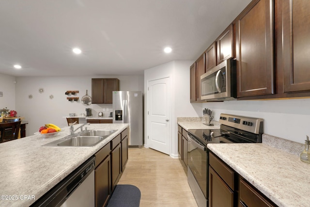 kitchen featuring a sink, light wood-style flooring, appliances with stainless steel finishes, and recessed lighting