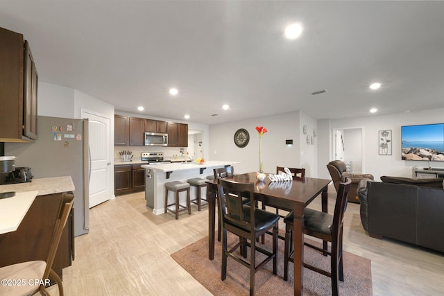 dining space featuring light wood finished floors, visible vents, and recessed lighting