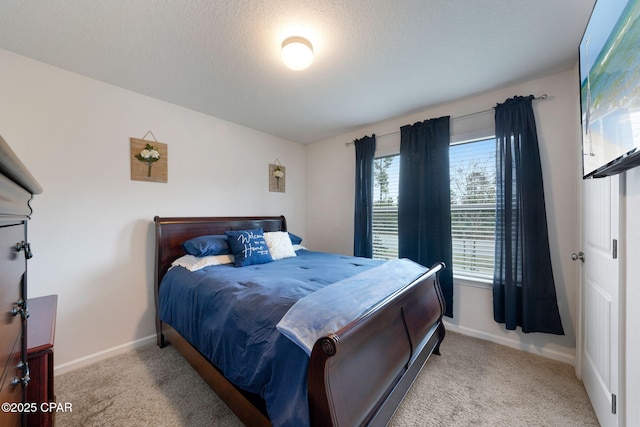 carpeted bedroom featuring a textured ceiling and baseboards