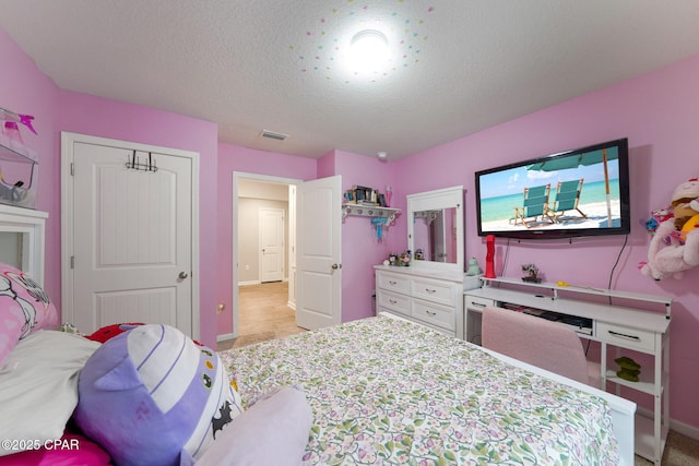 bedroom featuring visible vents, baseboards, and a textured ceiling