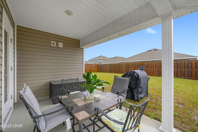 view of patio / terrace with grilling area, outdoor dining space, and a fenced backyard
