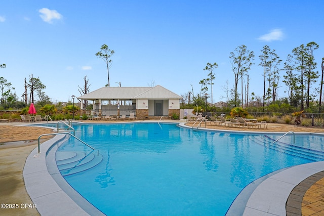 pool with a patio area and fence