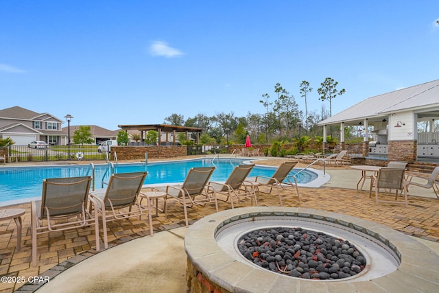 pool featuring a patio area, fence, and an outdoor fire pit