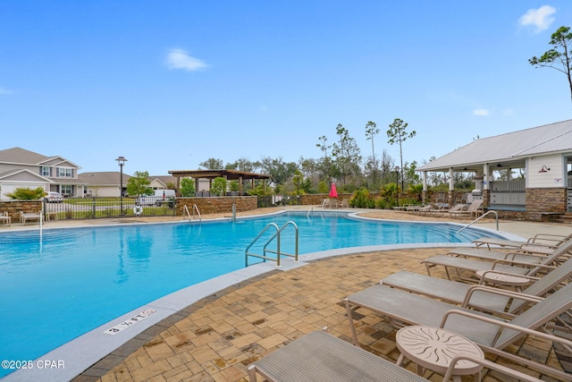 community pool with a patio and fence