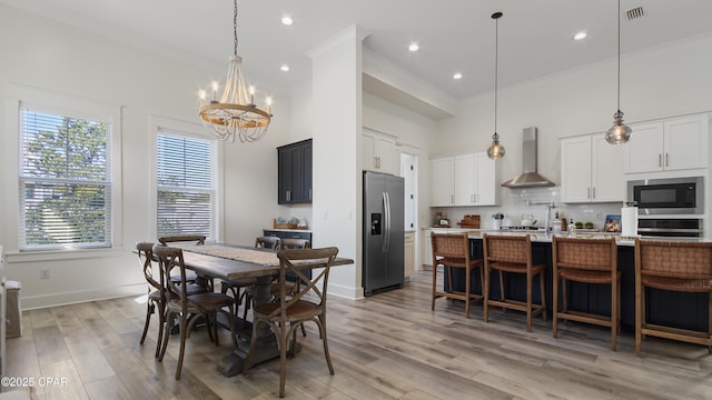 150 Grande Pointe Cir, Inlet Beach, FL 32461 - dining space with a chandelier, crown molding, light wood-style floors, a towering ceiling, and recessed lighting