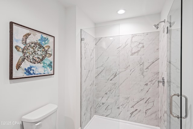 full bathroom featuring a shower with door and toilet