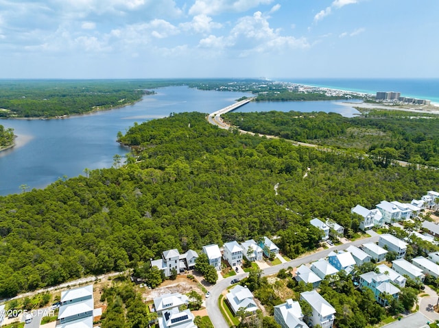 birds eye view of property featuring a water view and a wooded view