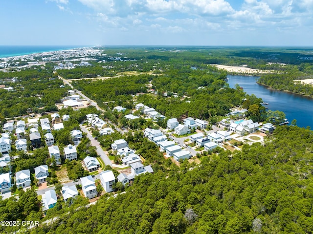 aerial view featuring a residential view, a water view, and a view of trees