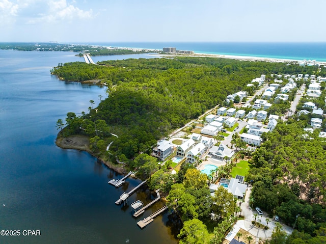 drone / aerial view featuring a water view and a forest view